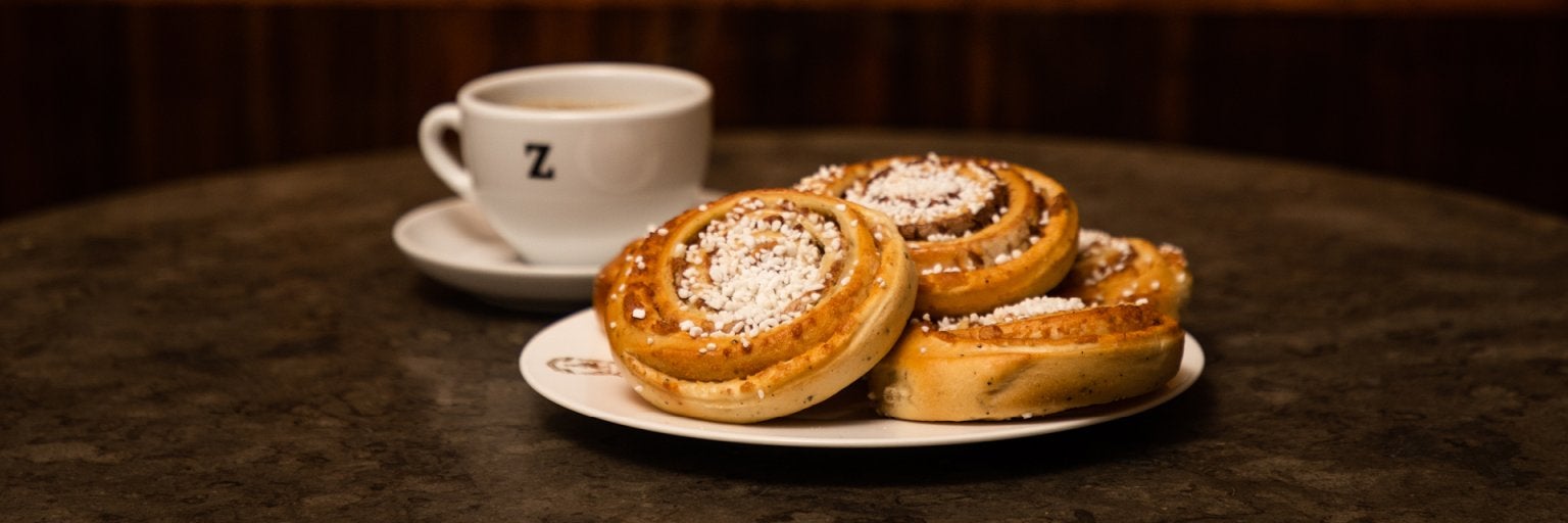 ett fat med kanelbullar och en kopp kaffe