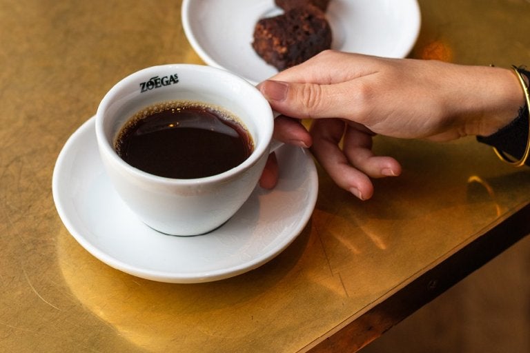 Hand grabbing coffee cup