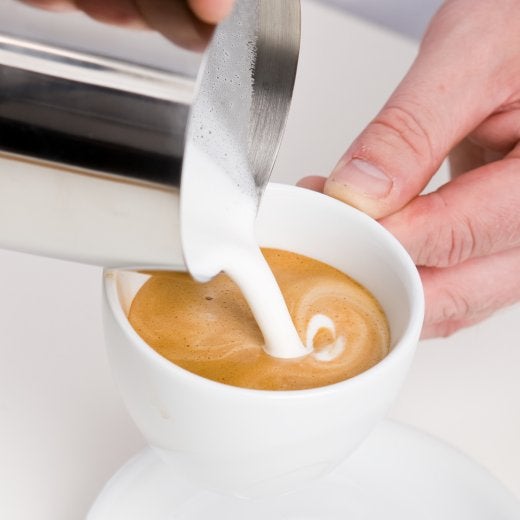 koppkaffe med mjölk som ska hällas i