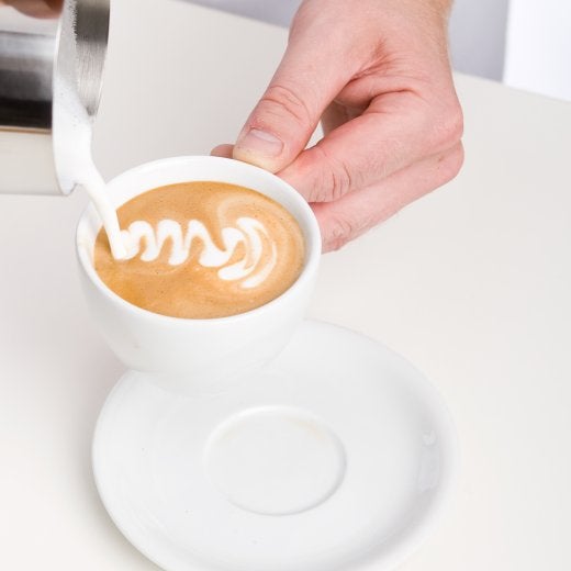 koppkaffe med mjölk som ska hällas i