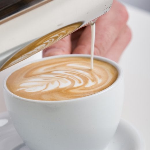 koppkaffe med mjölk som ska hällas i