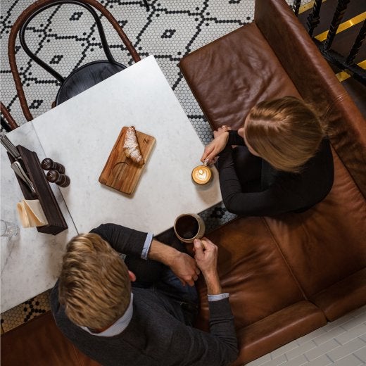 två personner dricke kaffe vid ett bord 