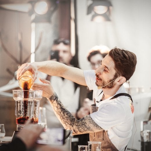 man häller kaffebönor i en maskin 